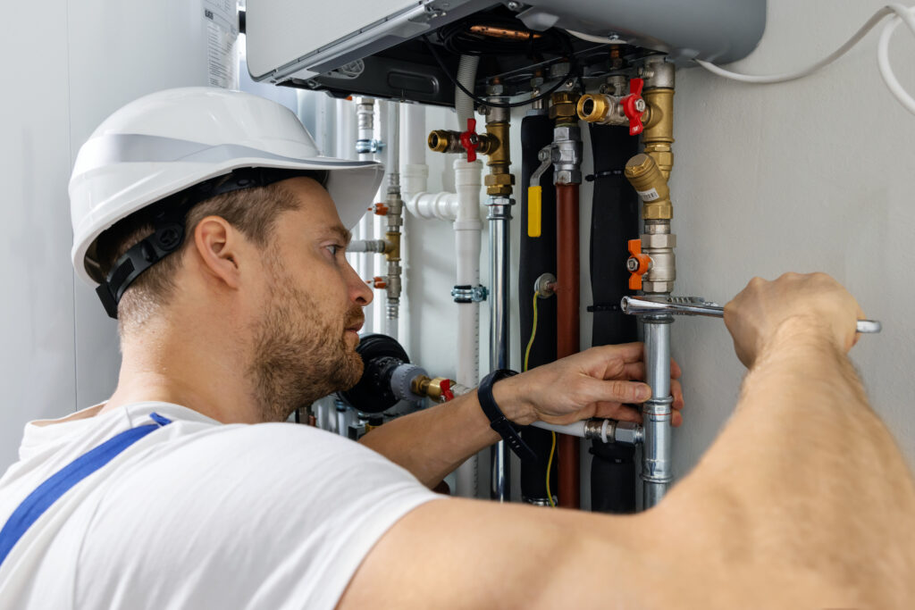image of worker installing pipes of house gas heating boiler