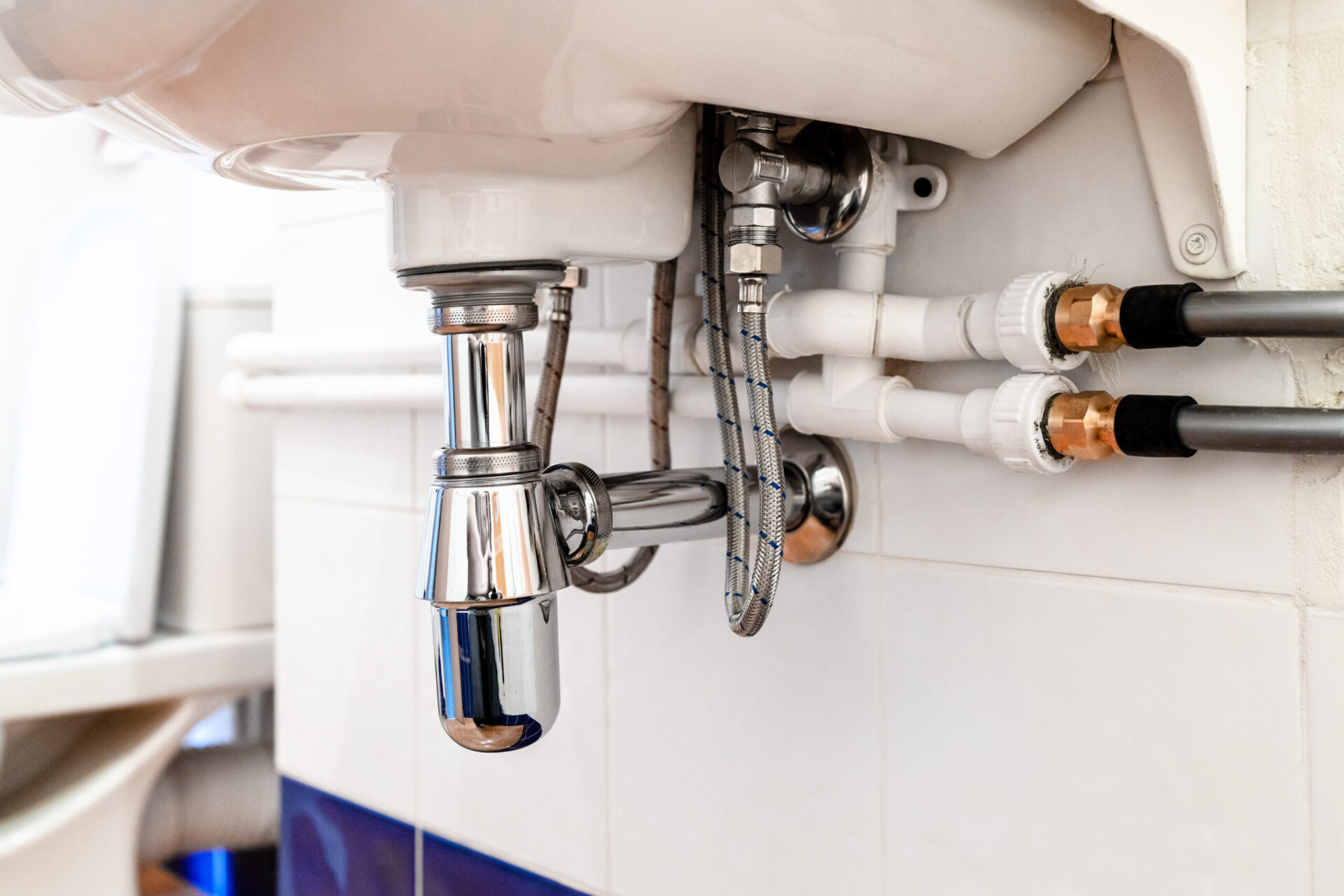 joint of polypropylene and flexible polyethylene plastic pipes under sink in toilet room